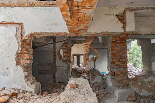 Explore the decaying ruins of an abandoned building with exposed bricks and destruction.